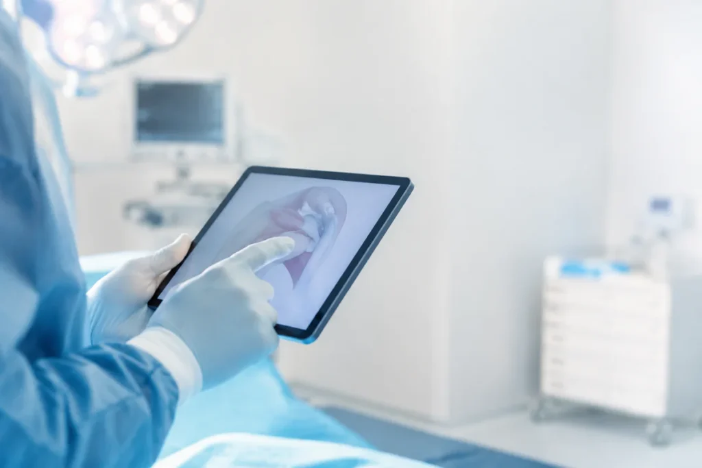 Surgeon's hands in sterile gloves reviewing a medical diagram on a tablet in a calm, modern clinical setting, symbolizing the