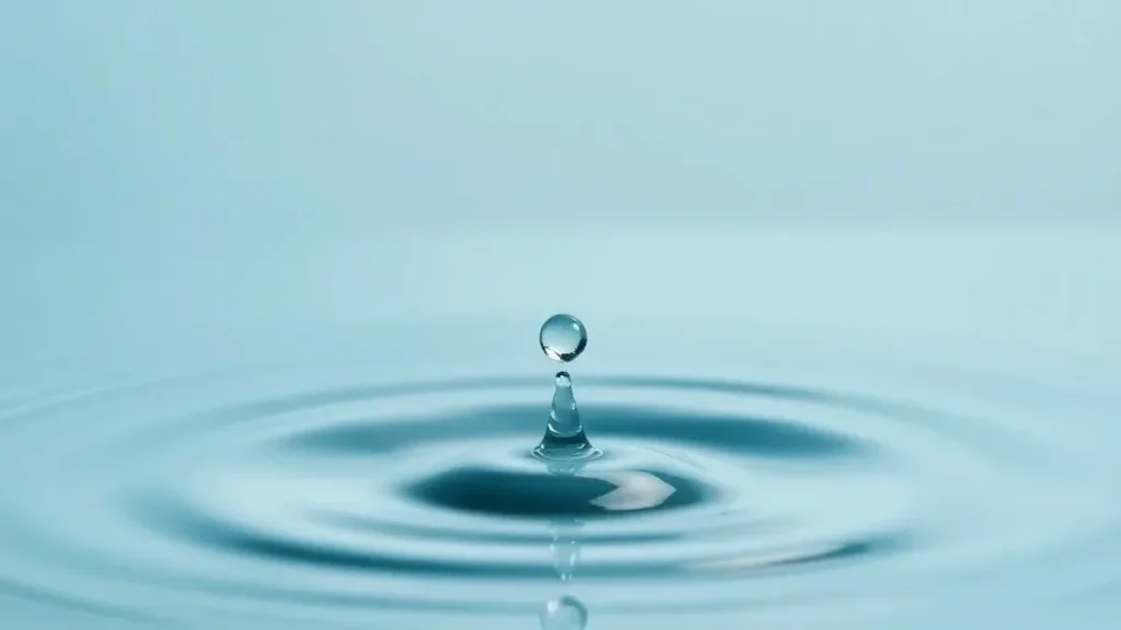 Abstract minimalist image of a single water droplet creating ripples on a calm blue surface, symbolizing the impact of excess
